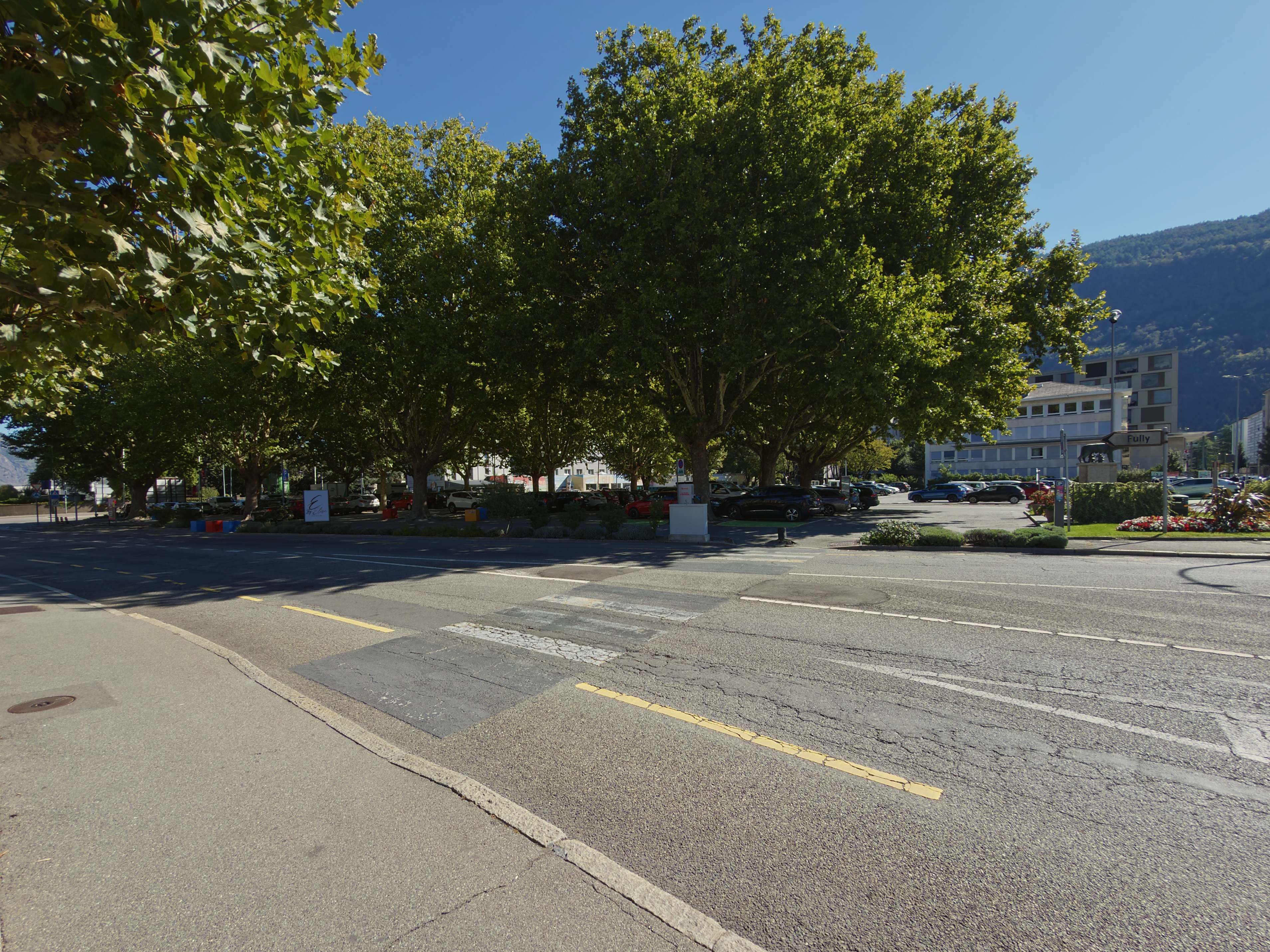 Grand parking arboré en face de la Galerie La Louve à Martigny
